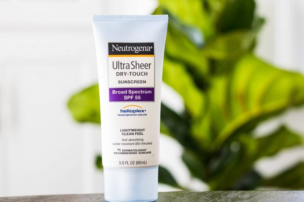 neutrogena ultra sheer sunscreen lotion in front of green plant
