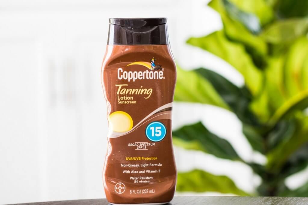 coppertone tanning lotion SPF 15 in front of green plant