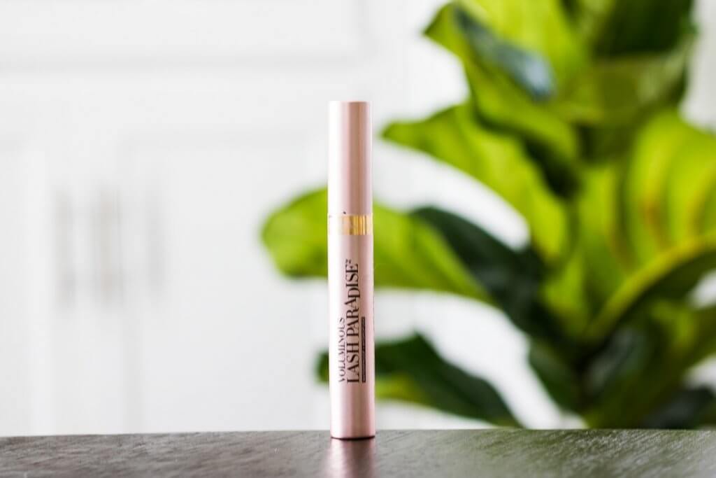 loreal lash paradise waterproof mascara in front of green plant